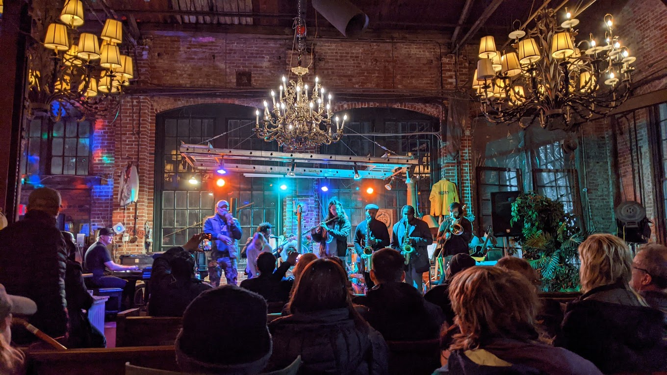 Main performance space with vintage chandeliers and exposed brick walls